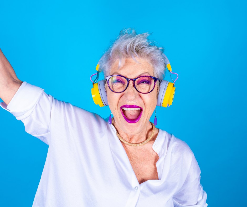 An artist dancing in pink headphones against a magenta backdrop